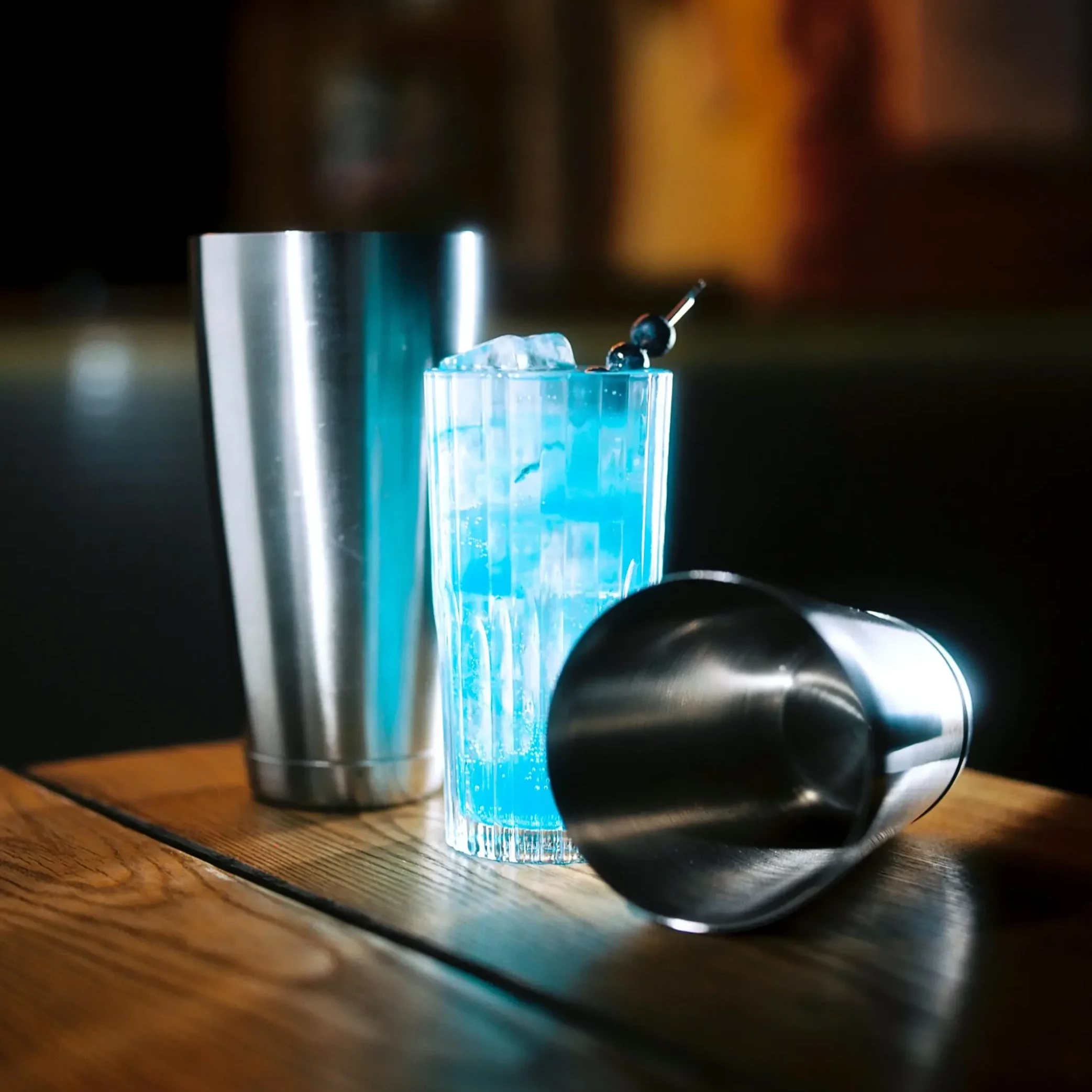 Glas mit blauem Gin Tonic und Cocktail Shaker